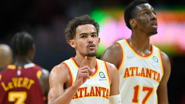 Trae Young walks beside teammate Onyeka Okongwu.